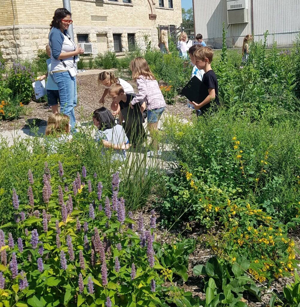 first grade children in pollinator garden