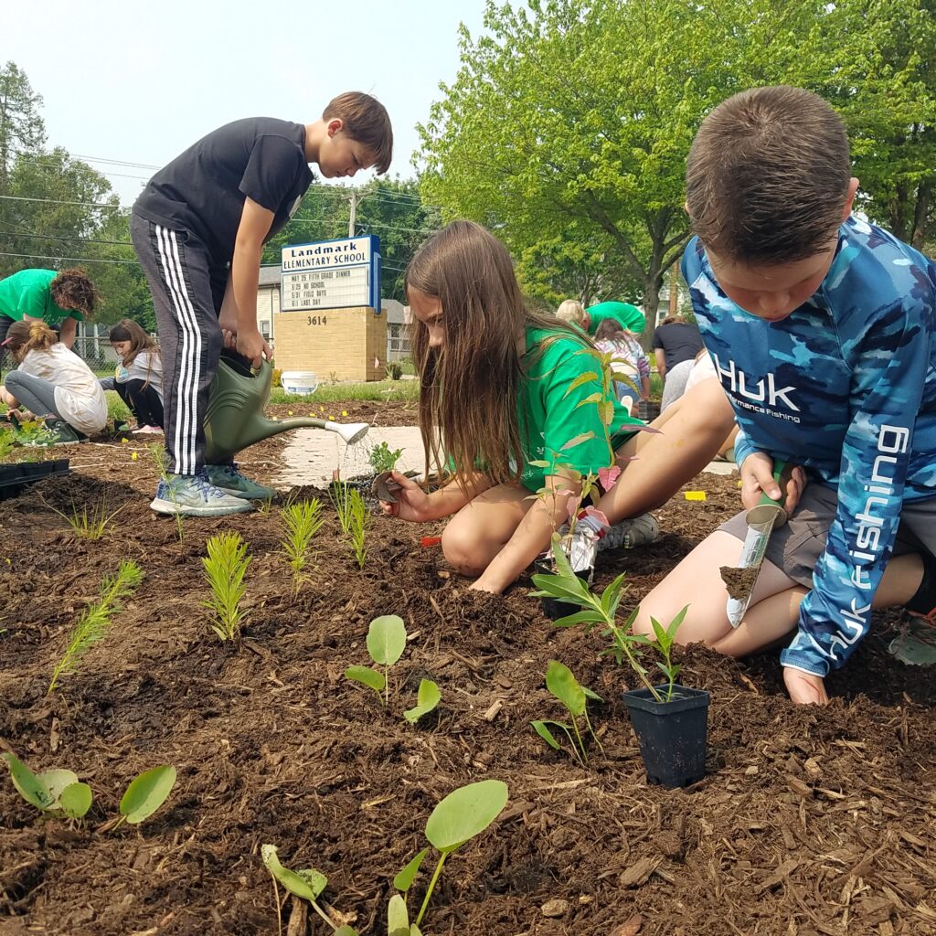 students planting native pollinator garden
